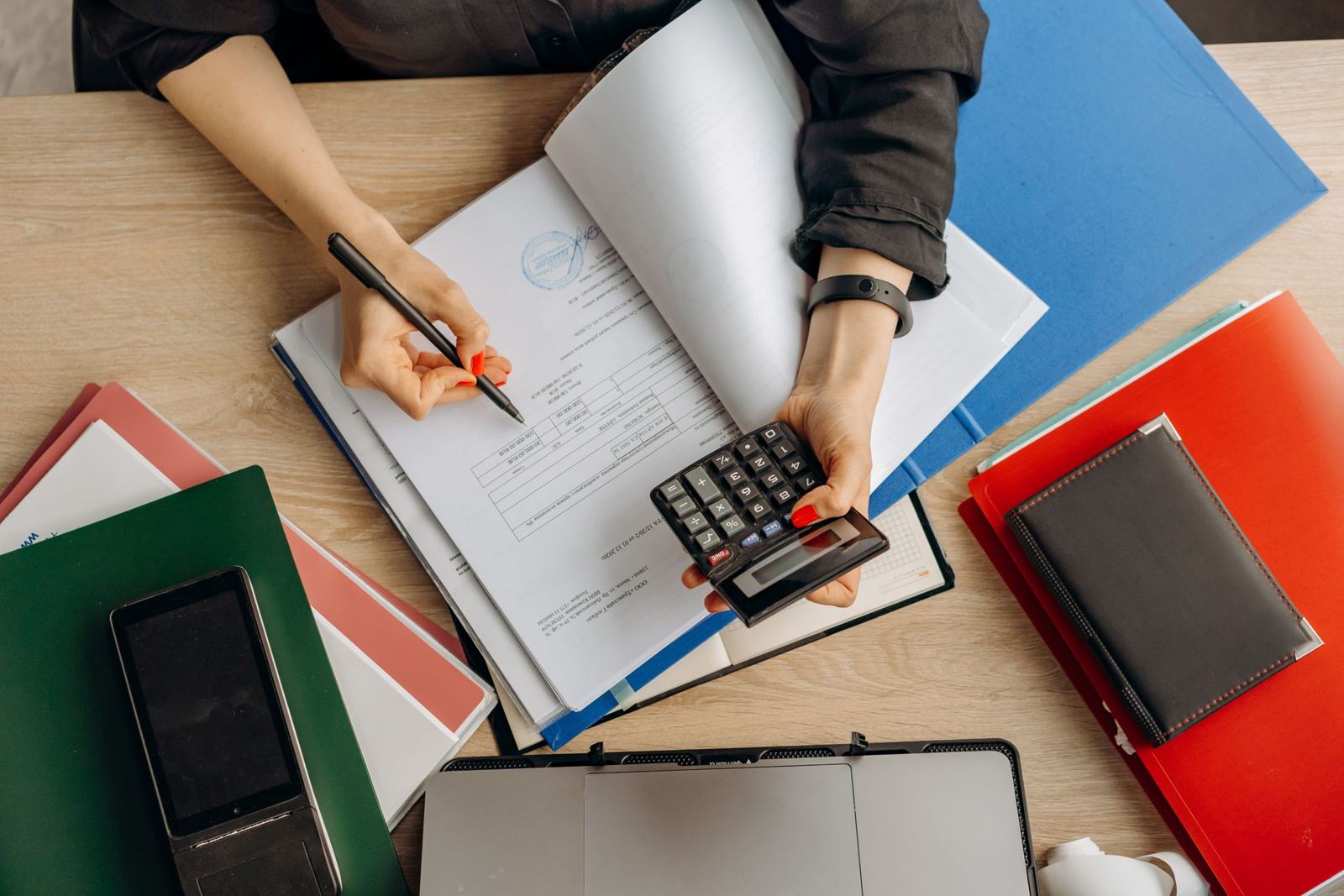 Reviewing documents with a calculator at a desk